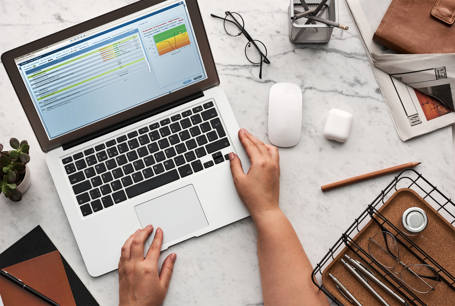 Statistics on a laptop with airpods and plant on the desk